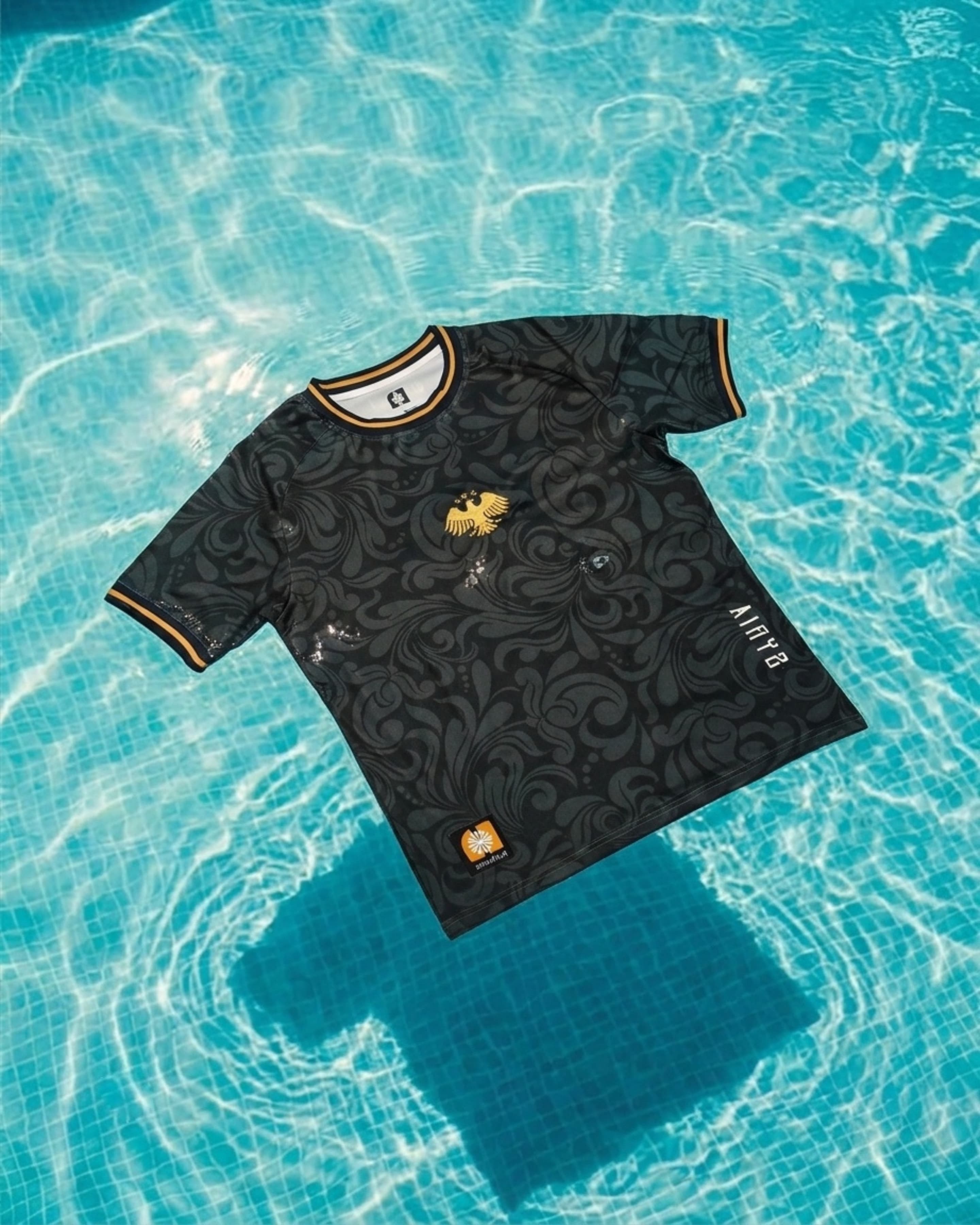Ornament Jersey in Obsidian — floating in clear blue pool water with light caustics